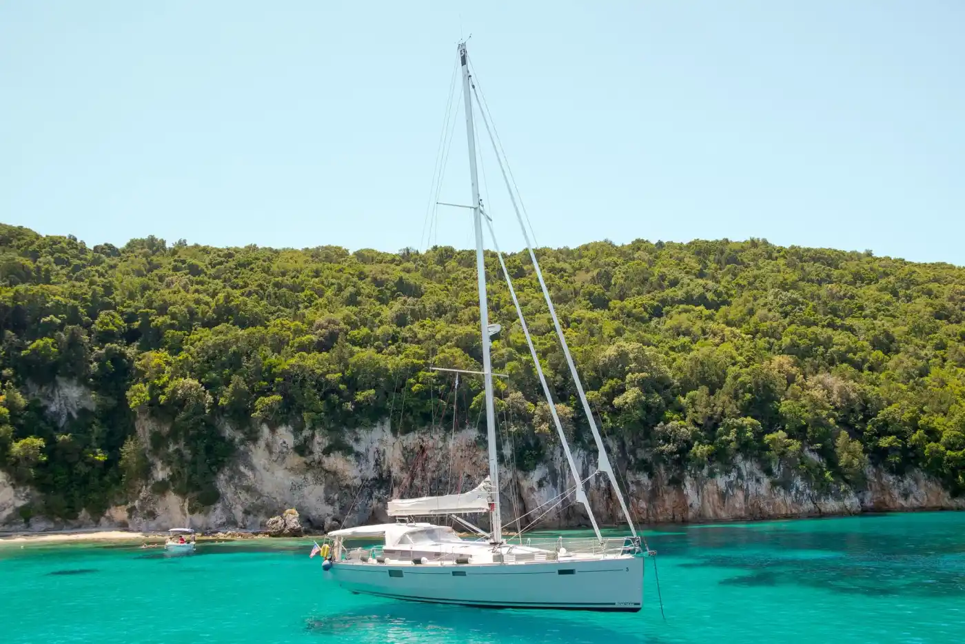 Yacht contemporain naviguant le long d’une côte méditerranéenne